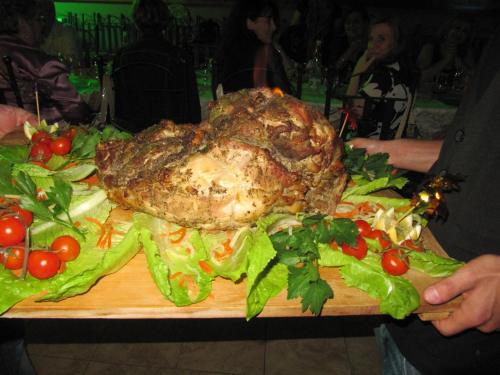 a large chicken on a cutting board with salad at Agriturismo Ghiritina in Francavilla di Sicilia