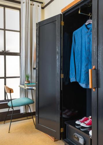 a closet with a black door and a chair at Freehand Los Angeles in Los Angeles