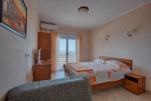 a bedroom with a bed and a window at Apartmani Djurovic in Dobra Voda