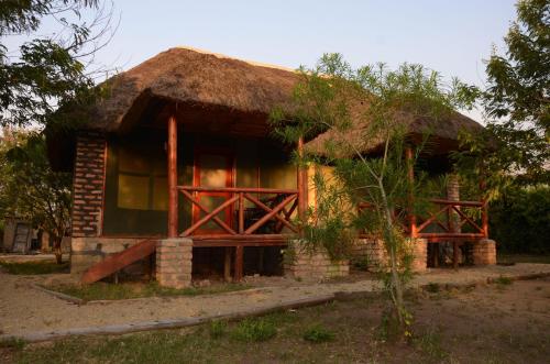 a small house with a thatched roof at Irungu Forest Safari Lodge in Katunguru