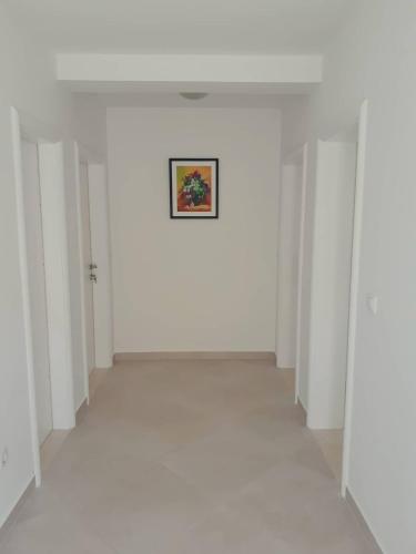 a room with white walls and a painting on the wall at Apartments Lidija in Cavtat