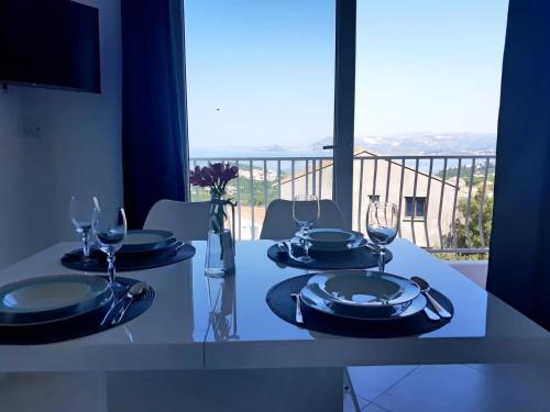 a table with plates and wine glasses on a balcony at Apartments Lidija in Cavtat