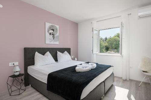 a bedroom with a large bed and a window at Apartments Lidija in Cavtat
