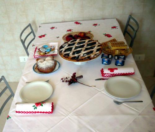 un tavolo con una torta e altro cibo sopra di La casetta a Ortona