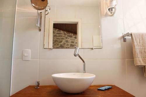 a bathroom with a bowl sink on a wooden table at Pousada Kico in Búzios