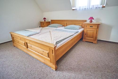 a large wooden bed in a room with two night stands at Pension Restaurant Bobrovník in Lipova Lazne