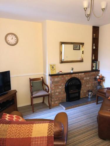 a living room with a fireplace and a mirror at Gilmore House in Ardglass