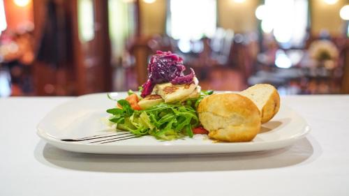 a plate with a salad and bread on a table at Pension Restaurant Bobrovník in Lipova Lazne