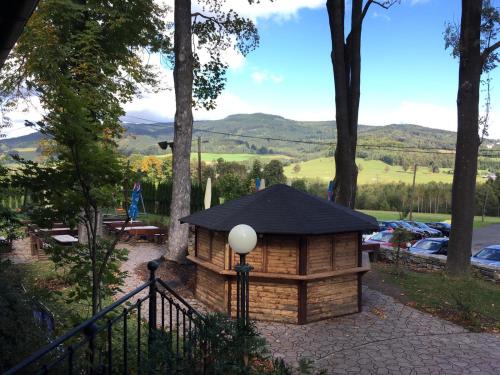 a log cabin in the woods with a fence at Pension Restaurant Bobrovník in Lipova Lazne
