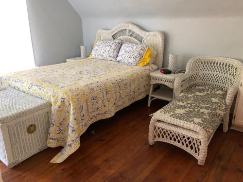 um quarto com uma cama e 2 cadeiras de vime em Lucy's Place em Bayfield