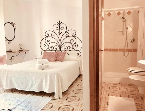 AggiusにあるGallura experiences Li Criasgiの白いベッドルーム(ベッド1台、バスルーム付)