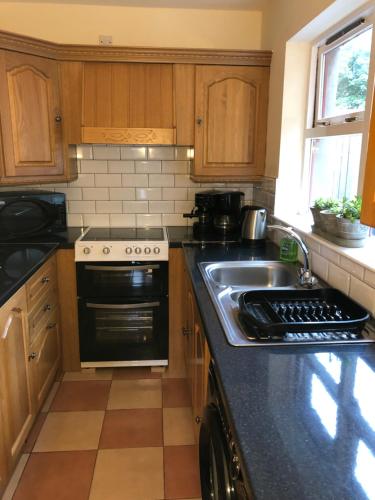 a kitchen with a sink and a stove at Gilmore House in Ardglass