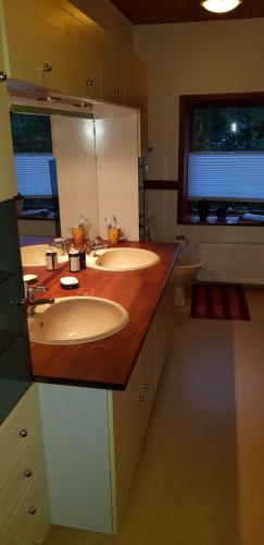 a bathroom with two sinks and a wooden counter top at Tjørnely in Østervrå