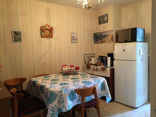 a kitchen with a table and a white refrigerator at Les Galets in Tracy-sur-Mer