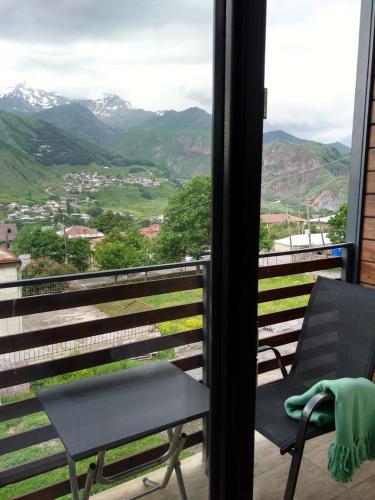 a chair on a balcony with a view of mountains at Hilltop Kazbegi in Stepantsminda