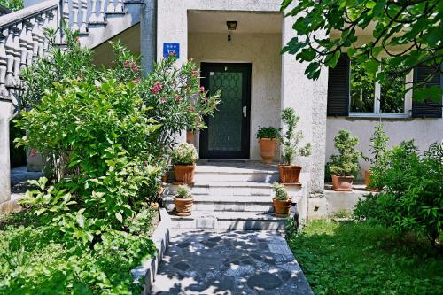 a front door of a house with potted plants at Apartment Gogo in Opatija