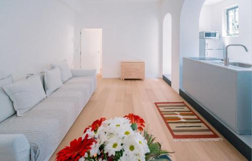 un soggiorno con divano e fiori sul pavimento di Alex Suite a Como