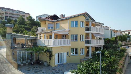 a large yellow building with white balconies on it at Apartments Tomislav in Trogir