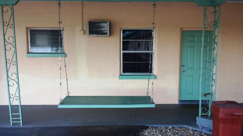 a porch swing hanging off the side of a house at Campbell Motel in Cocoa