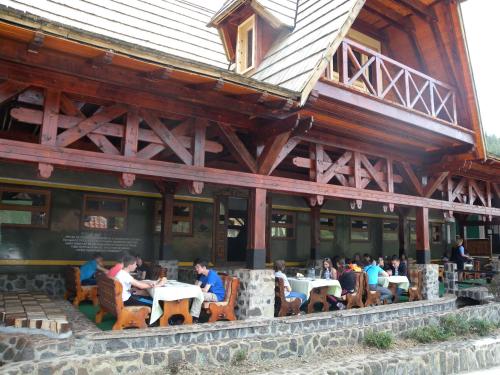 a group of people sitting at tables outside of a building at Konačište Osmica in Mokra Gora