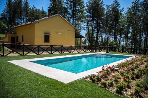 a swimming pool in a yard next to a house at Il Ginepro in Cortona