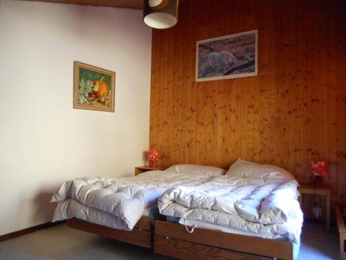 Cama en habitación con pared de madera en Apartment in Anzère, en Anzère