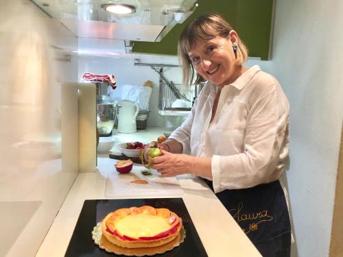 Een vrouw die in een keuken een taart klaarmaakt. bij B&B La Zuppa Inglese in Assisi