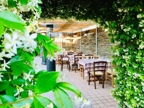 a restaurant with tables and chairs and flowers at LOCANDA VECCHIA FATTORIA in Monserrato