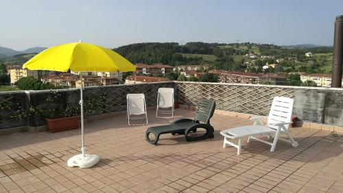 a group of chairs and an umbrella on a roof at Attico a Barberino di Mugello in Barberino di Mugello