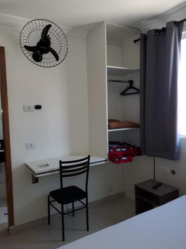 a room with a chair and a clock on the wall at Hotel Lisboa in Curitiba