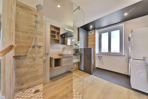 a kitchen with wooden walls and a glass shower stall at Locations des 3 sommets avec Sauna et Spa en Alsace in Sondernach