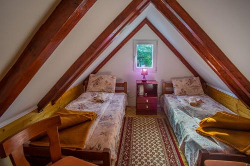a attic room with two beds and a window at Vuković Accommodation in Žabljak