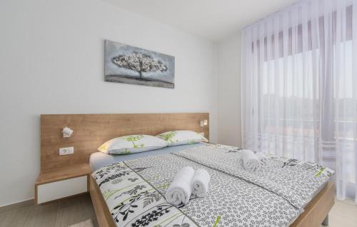 a bedroom with a bed with white sheets and a window at Apartments Hana in Funtana in Funtana