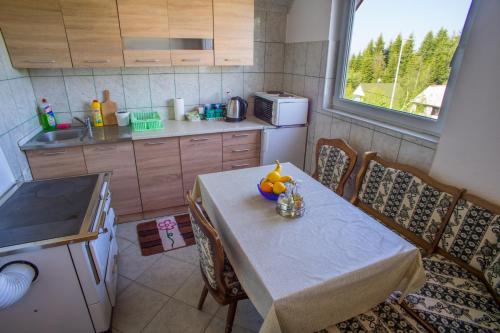 a small kitchen with a table and a table and chairs at Vuković Accommodation in Žabljak