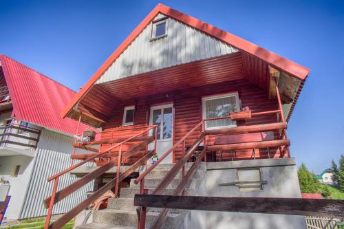 a wooden house with stairs leading up to it at Vuković Accommodation in Žabljak