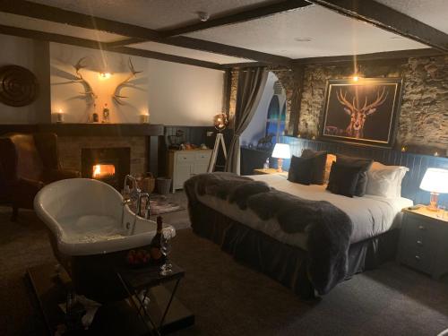 a bedroom with a large bed and a fireplace at Auldgirth Inn in Auldgirth
