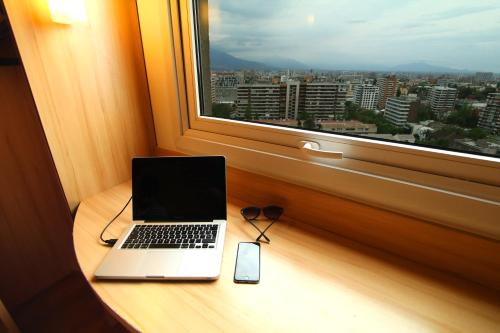 a laptop sitting on a table next to a window at ibis Santiago Estacion Central in Santiago
