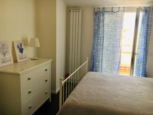 una camera con letto, cassettiera e finestra di Appartamento 13 a Polignano a Mare