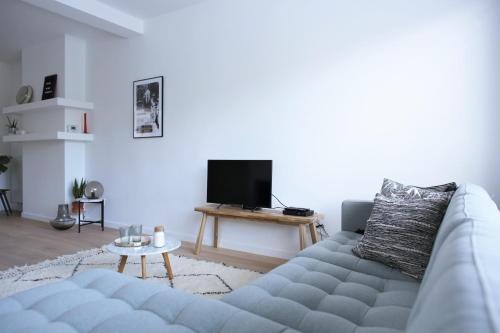 - un salon avec un canapé et une télévision dans l'établissement Brygga, à Bruges