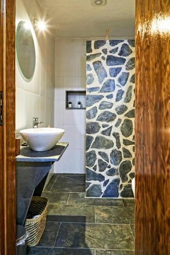 a bathroom with a sink and a stone wall at Recanto do Telheiro in Monsaraz