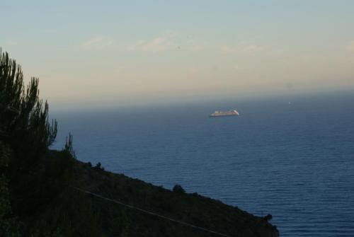 a view of the ocean with a house in the distance at Bungalow Sixdays 2 in Camporosso