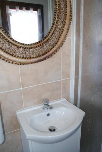 a bathroom with a white sink and a mirror at Bungalow Sixdays 2 in Camporosso