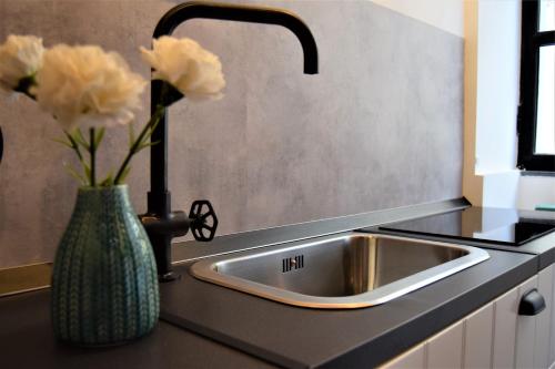 a kitchen sink with a vase with flowers in it at Il Limone Holiday Home Siracusa in Siracusa