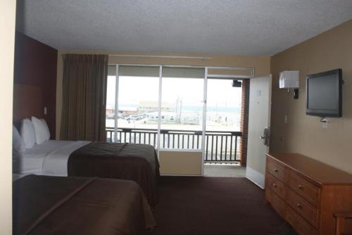 a hotel room with a bed and a large window at Oceanview Inn - Emerald Isle in Emerald Isle