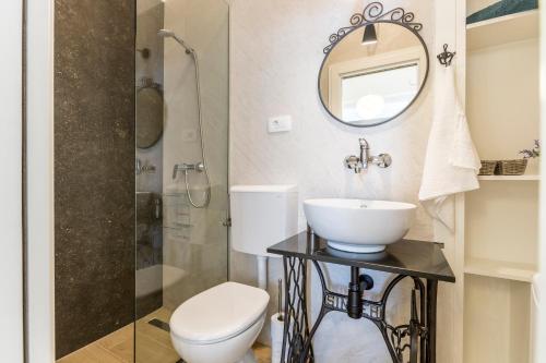 a bathroom with a sink and a toilet and a mirror at Apartments Sea Shore Split in Split