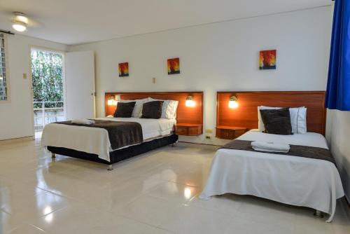 a hotel room with two beds in a room at Hotel Thama in Palmira