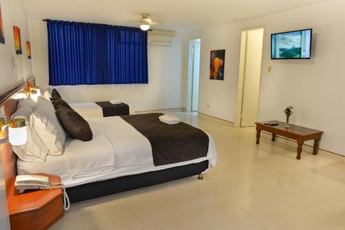 a bedroom with a large bed and a table at Hotel Thama in Palmira