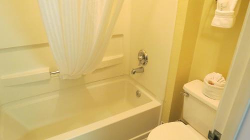 a bathroom with a white tub and a toilet at Baymont Inn & Suites by Wyndham Holbrook in Holbrook