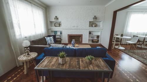 a living room with a blue couch and a table at Vila Milreu Guest House in Estói