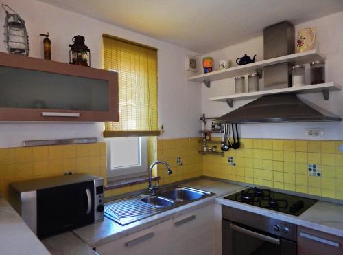 a kitchen with a sink and a microwave at Apartment Porozina, Cres in Cres